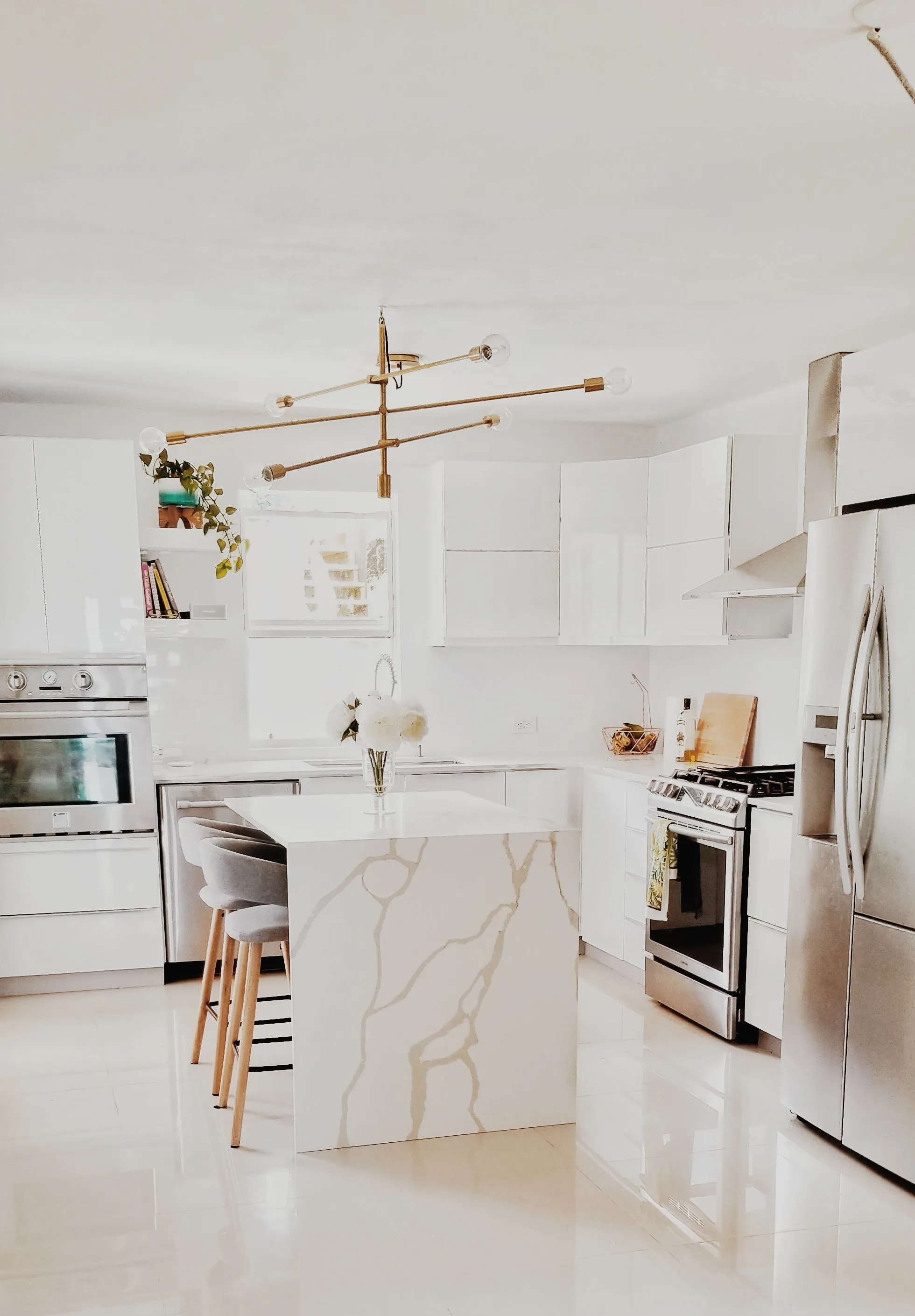 Îlot de cuisine en Calacatta veiné dans une cuisine blanche lumineuse